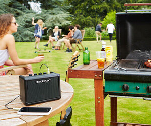 Mini ampli Blackstar FLY connecté à un téléphone lors d'un barbecue en plein air
